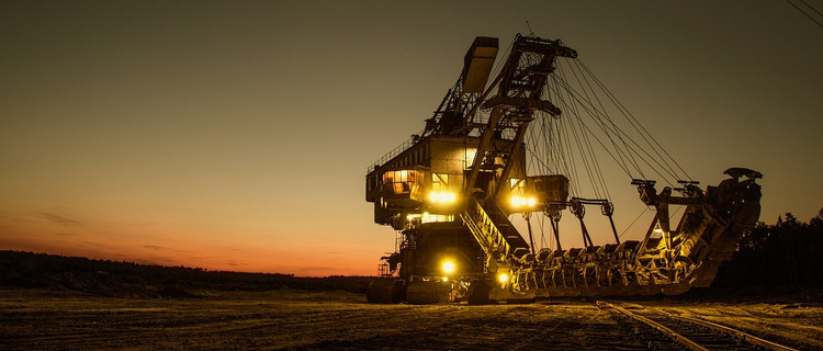 Bagger im Tagebau bei Nacht.
